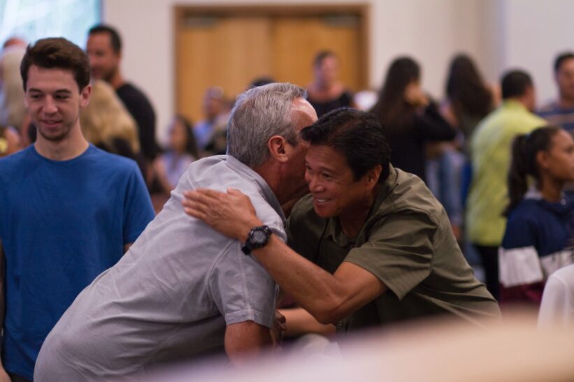 two men hugging on focus photography